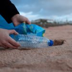 person holding clear plastic bottle