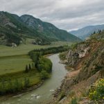 narrow river flowing through mountainous valley